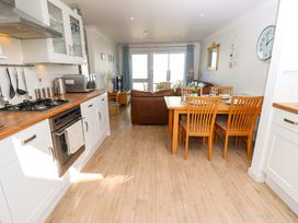 A kitchen and dining area with wooden furniture and white cabinets at Cape A9 Norton Near Freshwater