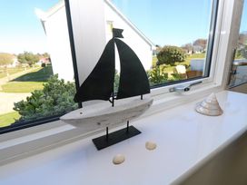 A window sill with a decorative sailboat and seashells in a room at Cape A9 in Norton Near Freshwater