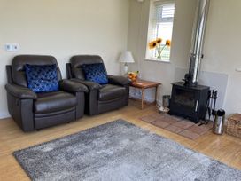 A living room with recliner chairs and a wood stove at Seadrift near Stalham