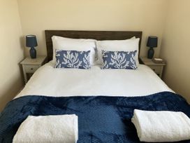 A bedroom with a bed and bedside table at Seadrift near Stalham