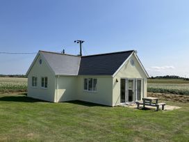 A house with a table and chairs in the yard at Seadrift near Stalham