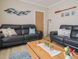 A living room with leather sofas and a wooden coffee table at 7 Cedar Drive Preston
