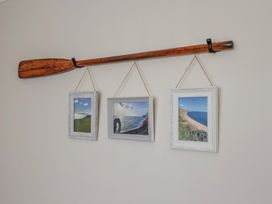 A rowing oar with three picture frames on a wall at 7 Cedar Drive Preston