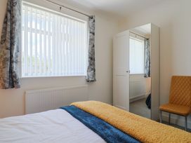 A bedroom with a bed and mirror at 7 Cedar Drive Preston