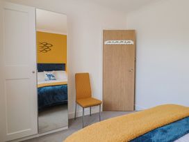 A bedroom with a mirror and a chair at 7 Cedar Drive Preston