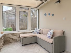 A conservatory with a sofa and decorative pillows at 7 Cedar Drive Preston