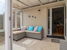 A conservatory with a sofa and cushions at 7 Cedar Drive in Preston