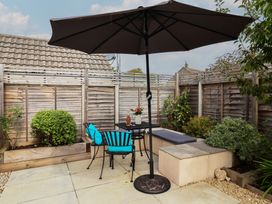 A garden with a table and chairs under an umbrella at 7 Cedar Drive, Preston
