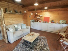 A living room with a sofa and kitchen area at The Lodge in 