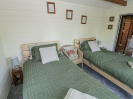 A bedroom with two beds, a bedside lamp and a chair at The Lodge in 