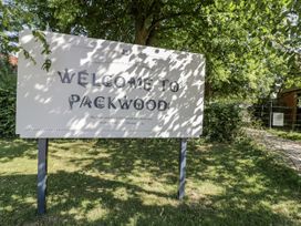 A welcome sign at Packwood with greenery and a pathway