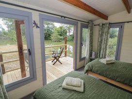 A bedroom with two beds and a view of the decking at Carps Well Lodge Hatton near Shrewley