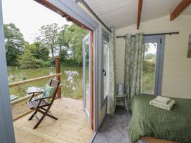A bedroom with a bed and a chair at Carps Well Lodge in Hatton near Shrewley