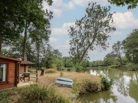 An outdoor view with wooden cabin and river at Carps Well Lodge Hatton near Shrewley