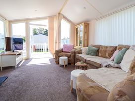A living room with a sofa and television at 152 Central Park, Prestatyn