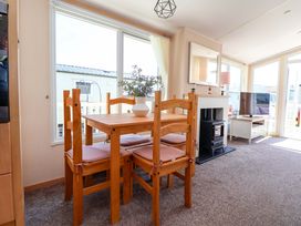 A dining area with a table and chairs at 152 Central Park in Prestatyn
