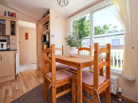 A dining room with a table and chairs at 152 Central Park Prestatyn