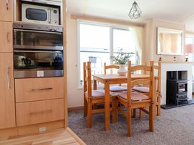 A dining room with a table and chairs at 152 Central Park in Prestatyn