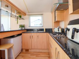 A kitchen with cabinets and a sink at 152 Central Park Prestatyn