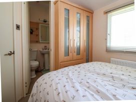 A bedroom with a bed and wardrobe at 152 Central Park in Prestatyn