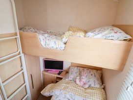 A bedroom with a bunk bed and a television at 152 Central Park, Prestatyn