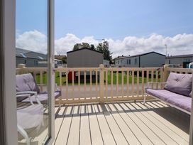 A balcony with seating overlooking caravans at 152 Central Park in Prestatyn