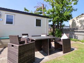 An outdoor dining area with a table and chairs at 152 Central Park in Prestatyn