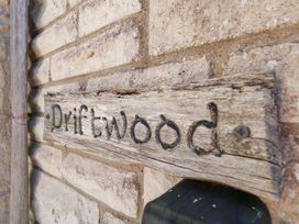 A wooden sign that reads Driftwood on a brick wall at Driftwood in Weymouth