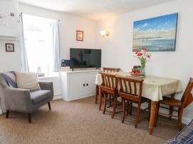A dining room with a table and chairs at Driftwood in Weymouth