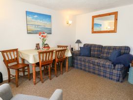 A dining room with table and chairs at Driftwood in Weymouth