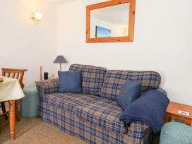 A living room with a sofa and lamp at Driftwood in Weymouth