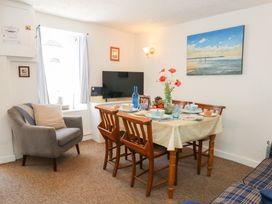 A dining room with a table and chairs at Driftwood in Weymouth