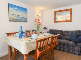 A dining room with a table set for meals at Driftwood in Weymouth