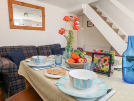 A dining room with a table set for meals at Driftwood in Weymouth