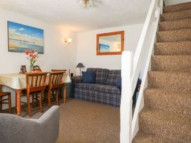 A living room with a sofa and dining area at Driftwood in Weymouth
