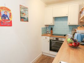 A kitchen with a stove, oven, and fruit bowl at Driftwood in Weymouth