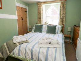 A bedroom with a double bed and wooden furniture at Driftwood in Weymouth