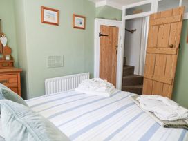 A bedroom with a bed and dresser at Driftwood in Weymouth