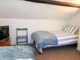 A bedroom with two beds and a television at Driftwood in Weymouth