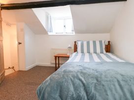 A bedroom with a bed and table at Driftwood in Weymouth