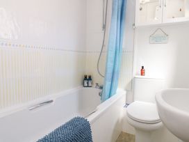 A bathroom with a bathtub and toilet at Driftwood in Weymouth