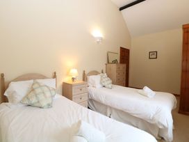 A bedroom with two single beds a nightstand with a lamp a chest of drawers and a painting on the wall at Beechwood in Wood Norton near Foulsham