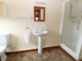 A bathroom with a toilet sink mirror and enclosed shower at Beechwood in Wood Norton near Foulsham