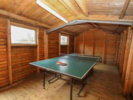 An indoor wooden room with a ping pong table and paddles at Beechwood in Wood Norton near Foulsham