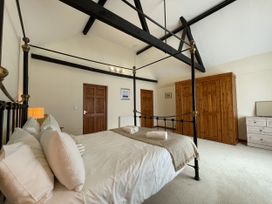 A bedroom with a metal bed and wooden furniture at Beechwood in Wood Norton near Foulsham