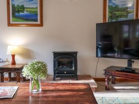 A living room with a television and a fireplace at Beechwood in Wood Norton