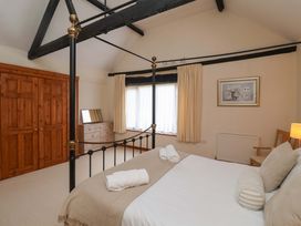 A bedroom with a four-poster bed and dresser at Beechwood in Wood Norton