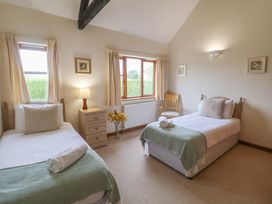 A bedroom with two beds and a window at Beechwood in Wood Norton