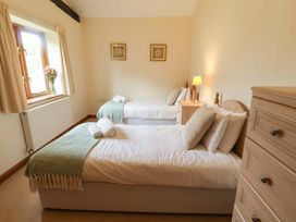 A bedroom with two single beds and a chest of drawers at Beechwood in Wood Norton