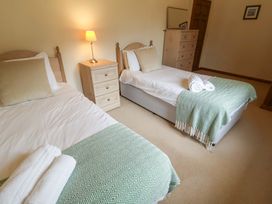 A bedroom with two beds and a lamp at Beechwood in Wood Norton